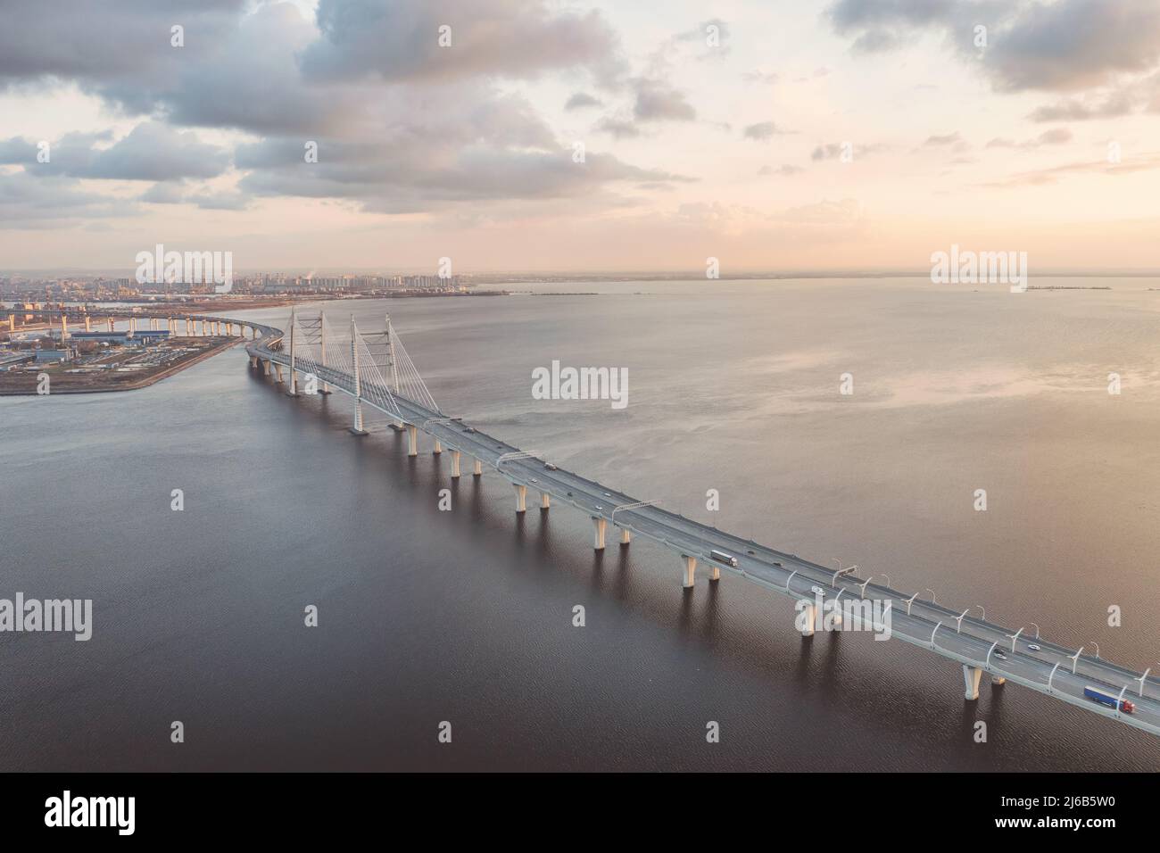 Panoramic industrial landscape with  elevated highway over sea in Saint Petersburg, Russia aerial view at sunset. Landscape with bridge, cloudy sky an Stock Photo