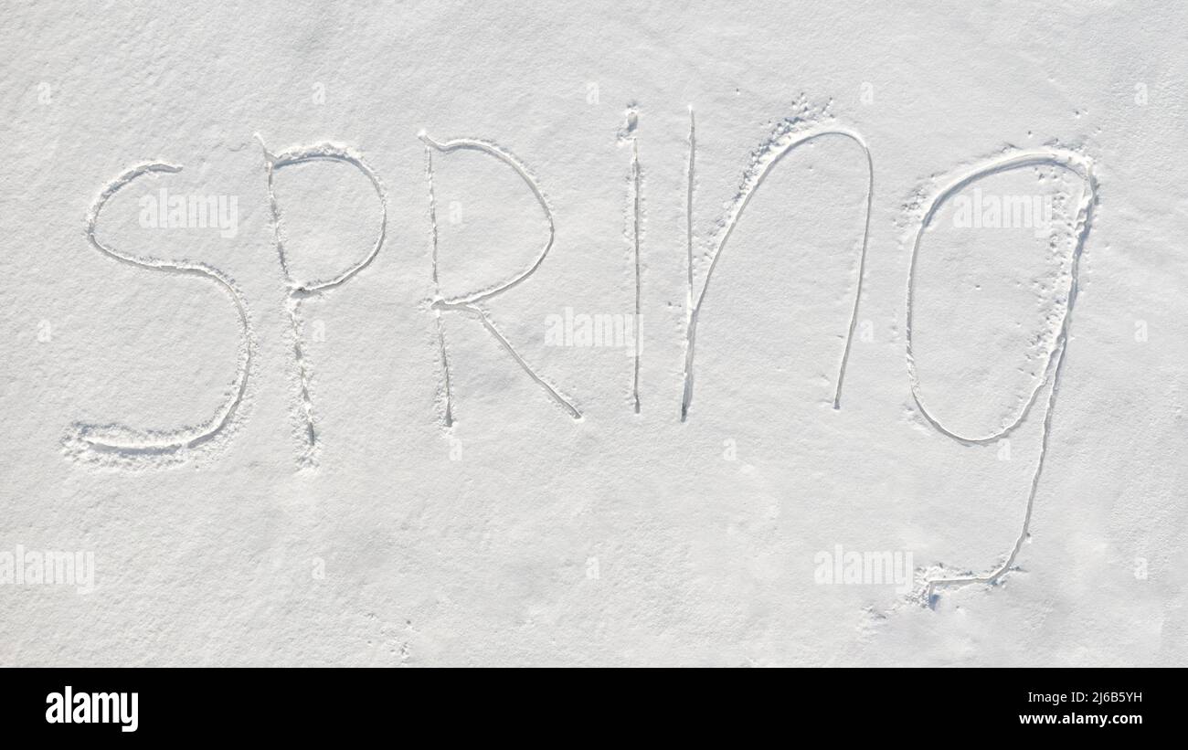 'Spring' text written on virgin snow. Top aerial view Stock Photo
