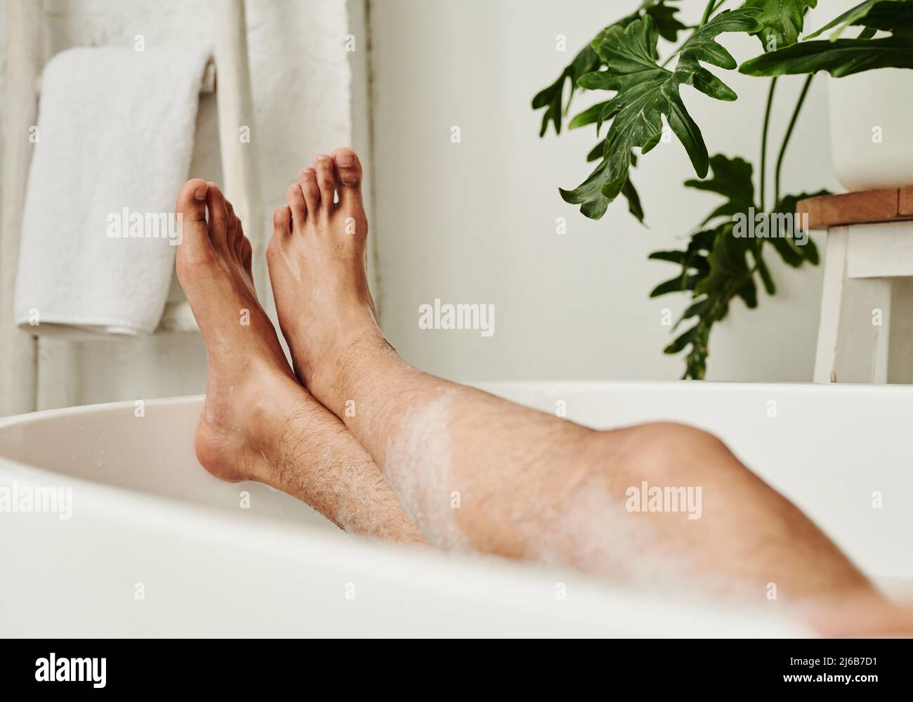 Closeup of man lying in bath with foam and relaxing during spa