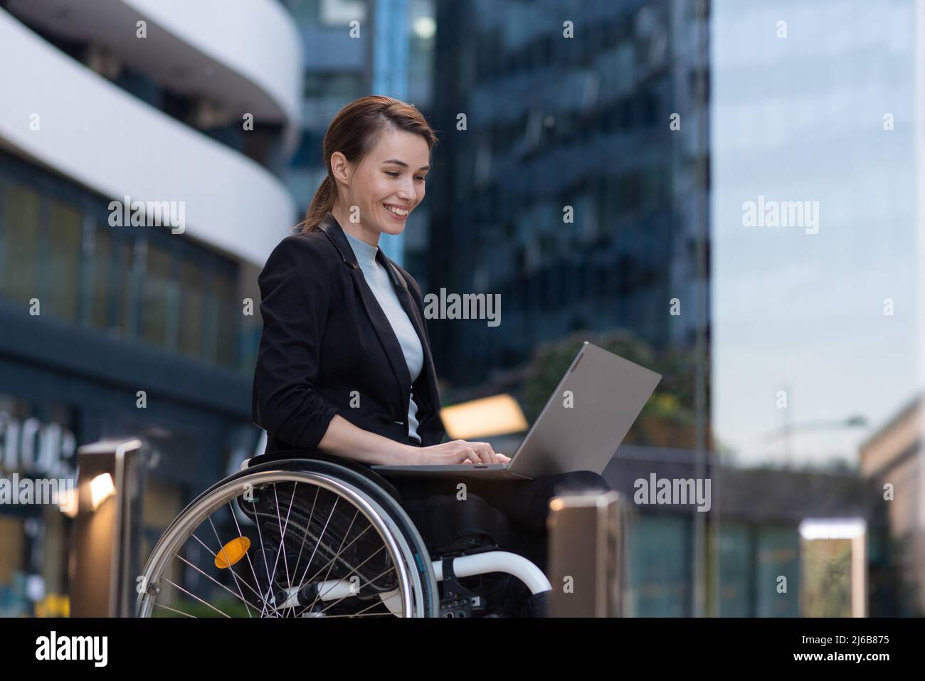 Businesswoman with a disability who uses a wheelchair working outside Stock Photo