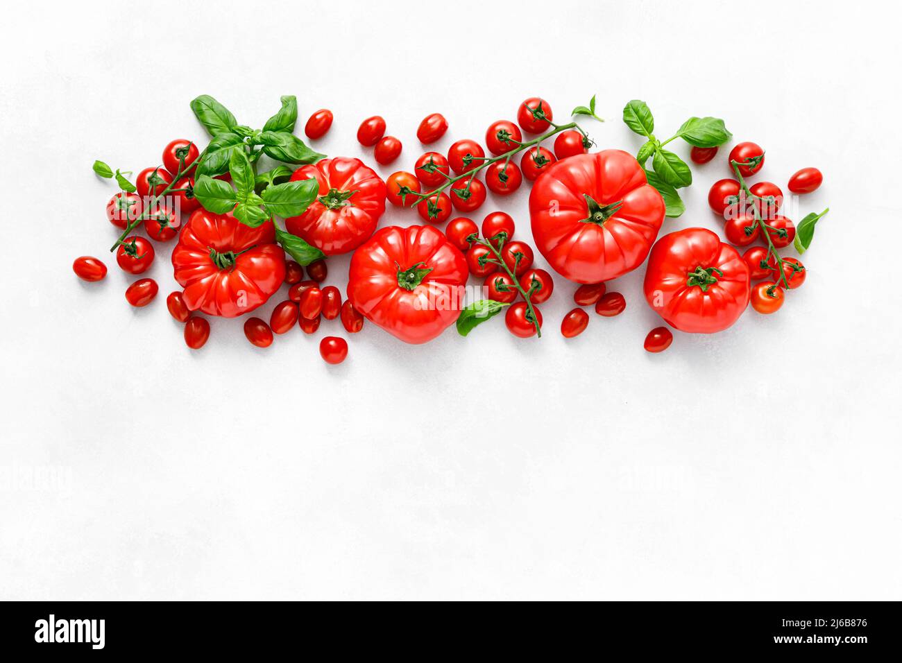 Tomatoes and basil on white background, top view, flat lay Stock Photo
