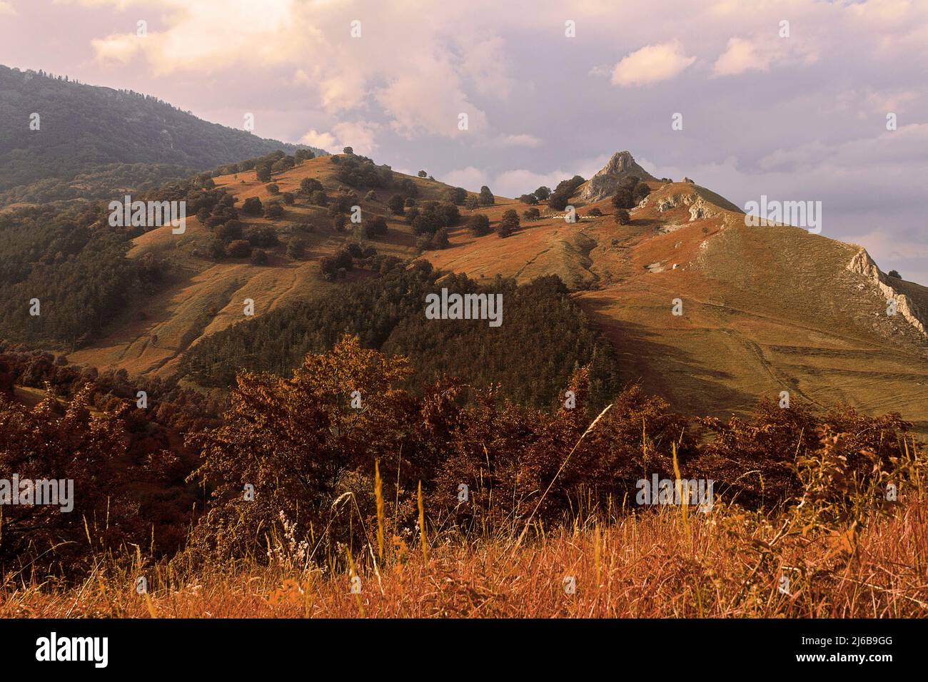 Orange colors of sunset over hills in Transylvania, Trascau mountains Stock Photo