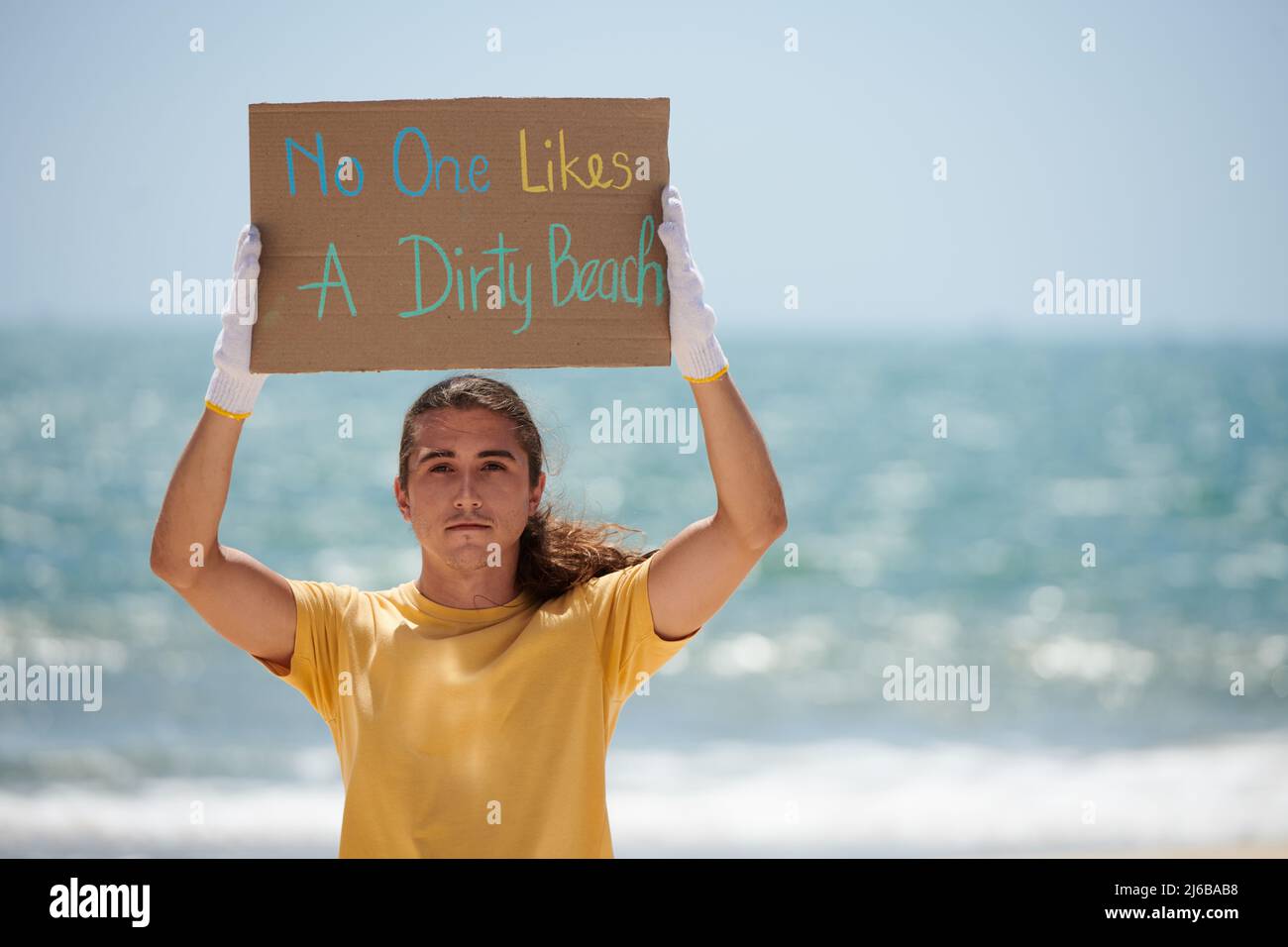 Young man showing no one likes dirty beach placard her made for protest Stock Photo