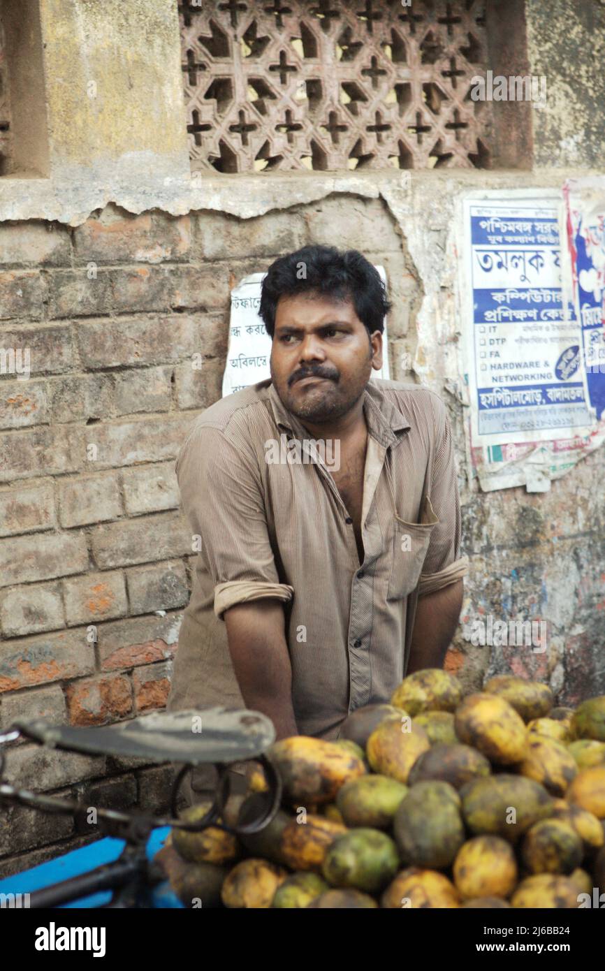 Mango seller waiting for customer on the side of a road in Tamluk