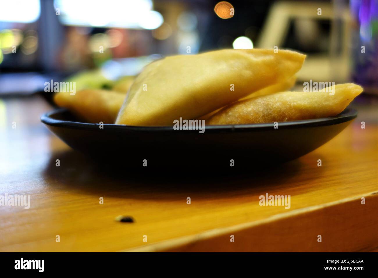 Samosas on a black plate as a close up Stock Photo
