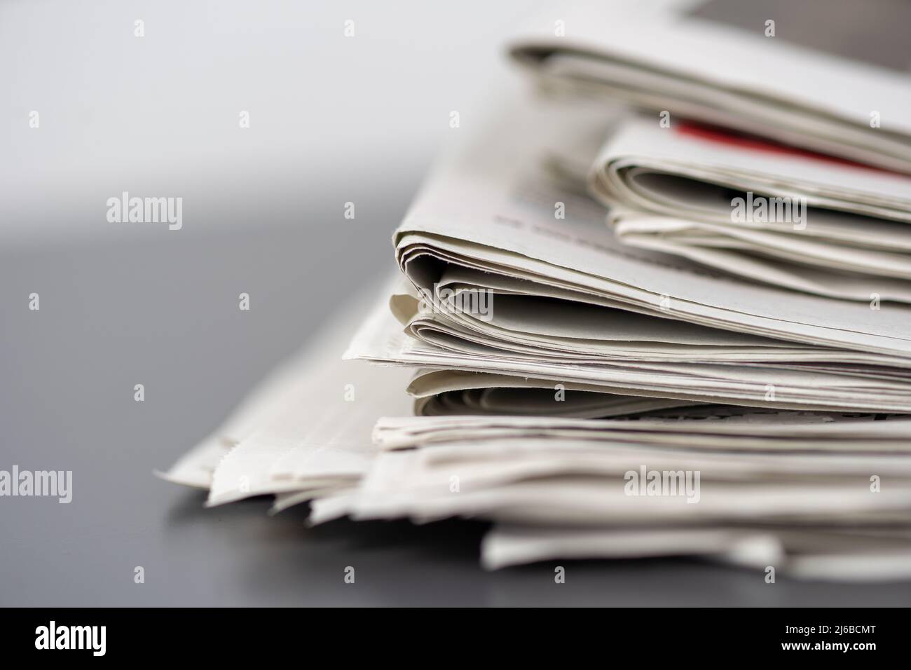 Macro shot of a stack of newspapers. The newspapers are folded and the articles are not legible Stock Photo