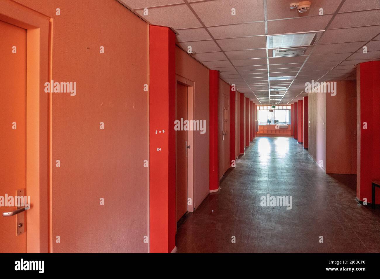AMSTERDAM/NETHERLANDS-FEBRUARY 24: An empty corridor of a prison with tiles on the floor and open steel cell doors on which texts are scratched The ce Stock Photo
