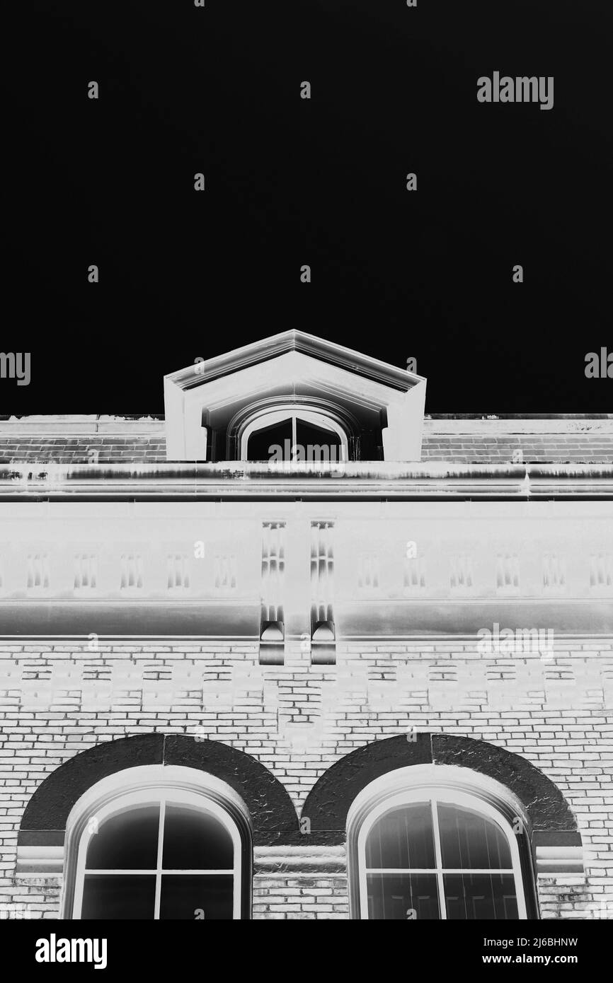 A traditional colonial attic window high on the roofline in high