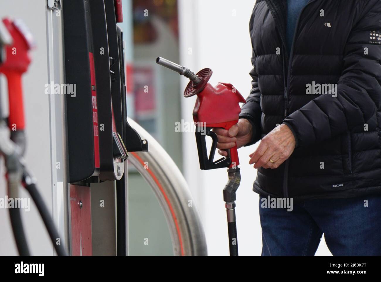 Man at a gas station filling up with petrol. Stock Photo