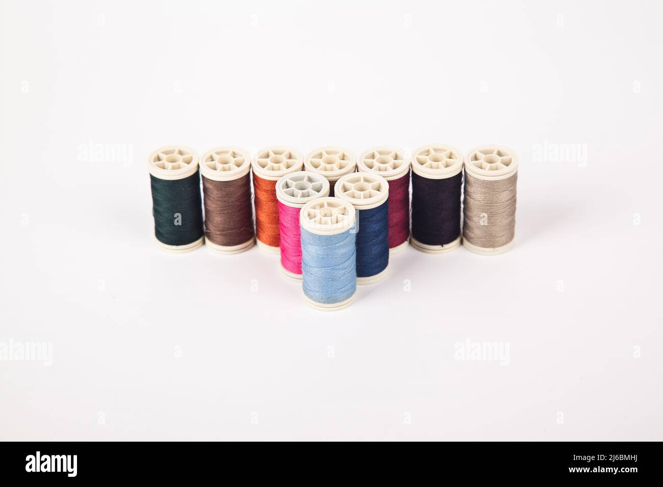 Spools and bobbins of thread for sewing in different colors, isolated ...