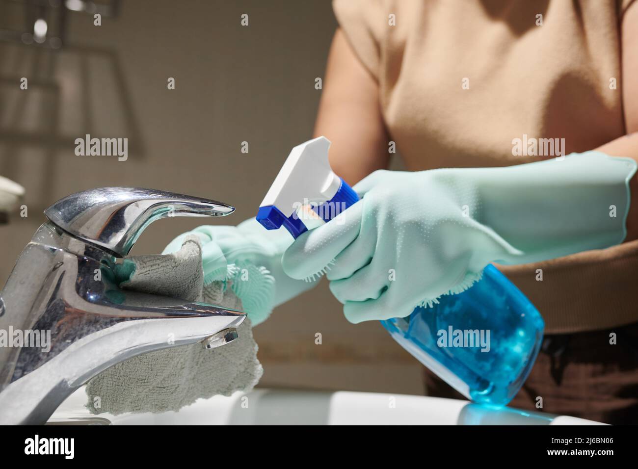 Cleaning service worker using spray detergent to remove hard water