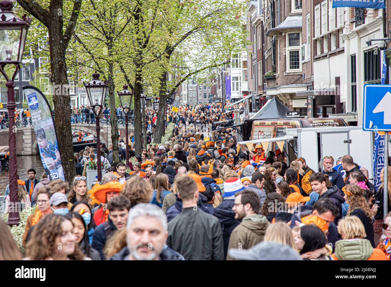 Crowds of people seen on the Streets of Amsterdam during the King's Day celebration. King's Day known as Koningsdag is an orange filled celebration for the king's birthday, a national holiday full of events across the country. Thousands of local revellers and tourists visited Amsterdam to celebrate and party around the canals while wearing orange clothes and the boats doing a parade in the water canals. Stock Photo