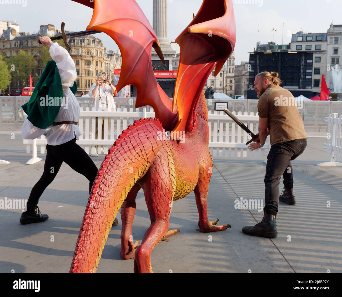 London, Greater London, England, April 23 2022: Staff at the St Georges day celebration in Trafalgar Square pretending to fight the dragon. Stock Photo