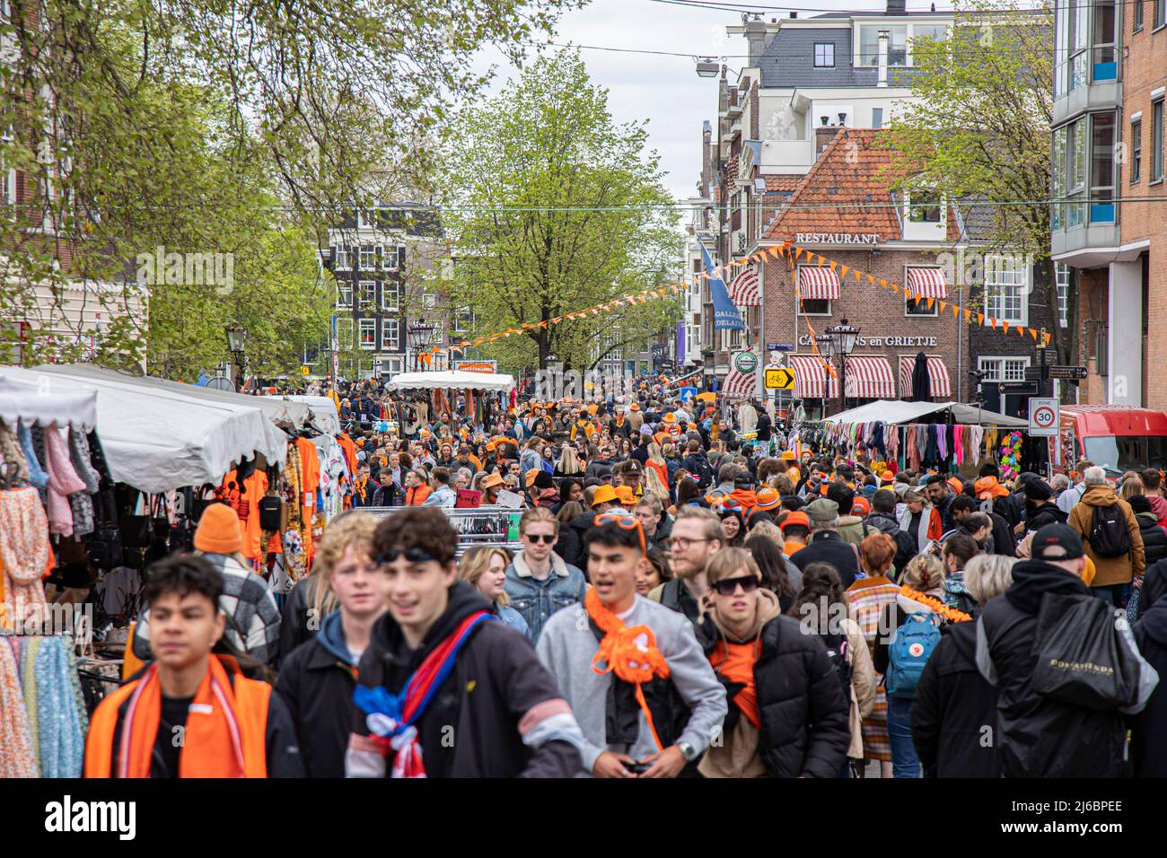 April 27, 2022, Amsterdam, Netherlands: Crowds of people seen on the Streets of Amsterdam during the King's Day celebration. King's Day known as Koningsdag is an orange filled celebration for the king's birthday, a national holiday full of events across the country. Thousands of local revellers and tourists visited Amsterdam to celebrate and party around the canals while wearing orange clothes and the boats doing a parade in the water canals. (Credit Image: © Nik Oiko/SOPA Images via ZUMA Press Wire) Stock Photo