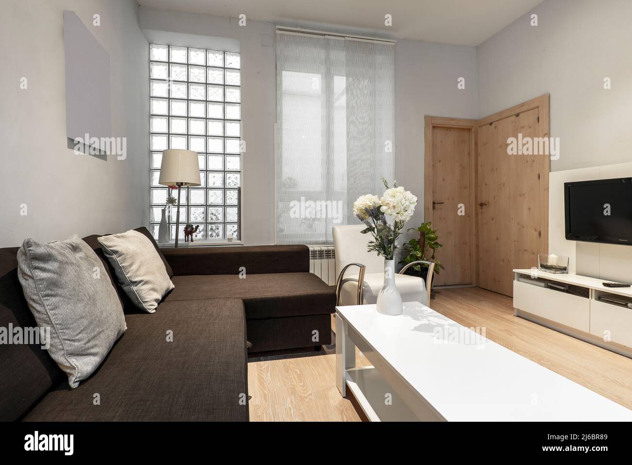 Living room with brown fabric sofa with chaise longue, white sideboard