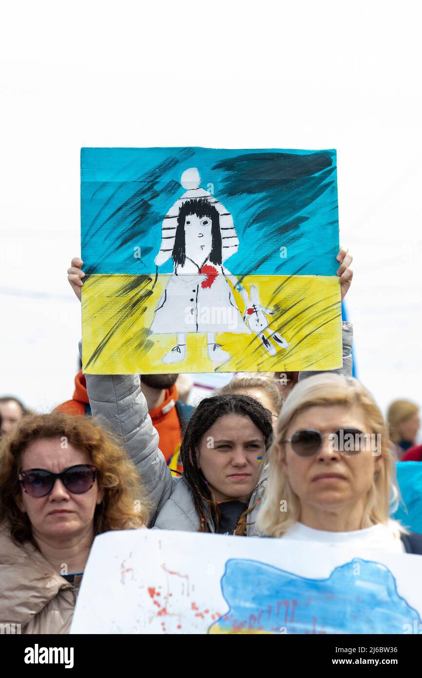 30 April 2022, Saxony, Dresden: A woman holds a banner in the air. The counter-event against pro-Russian rally entitled: 'Solidarity with the people of Ukraine! All together against Putin's war of aggression!' has several hundred participants. Photo: Daniel Schäfer/dpa Stock Photo