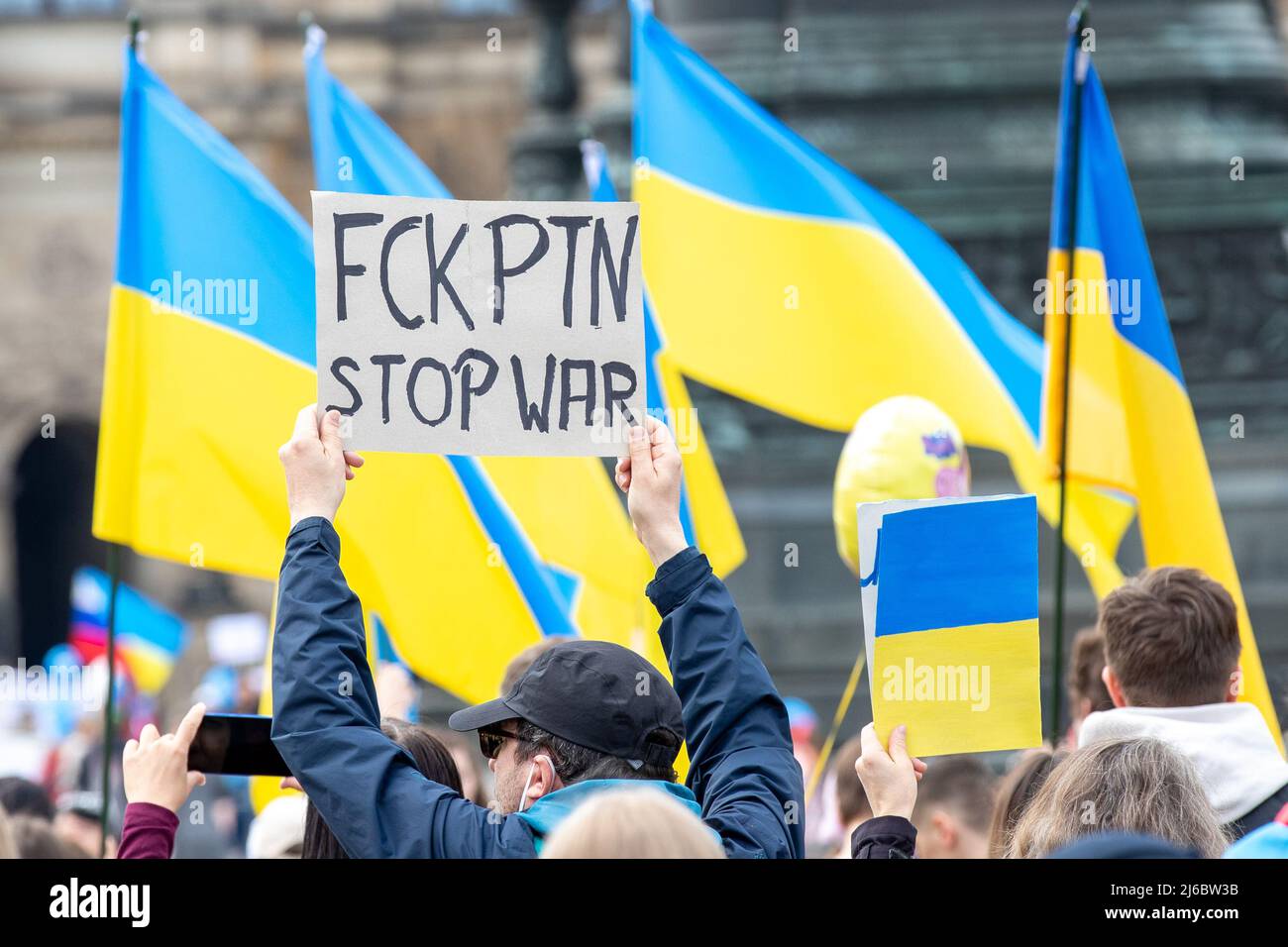 30 April 2022, Saxony, Dresden: A man holds a sign in the air, which is inscribed with 'FCK PTN STOP WAR'. The counter event against pro-Russian rally titled: 'Solidarity with the people of Ukraine! All together against Putin's war of aggression!'. Photo: Daniel Schäfer/dpa Stock Photo