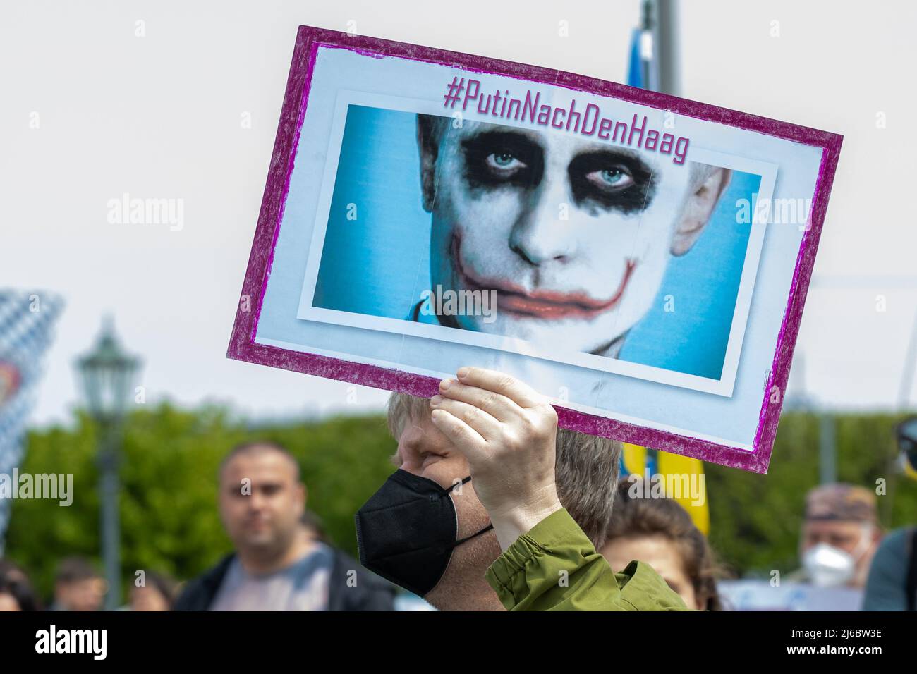 30 April 2022, Saxony, Dresden: A man holds up a sign with President Putin and the hashtag '#PutinNachDenHaag' at a counter-event against a pro-Russian rally entitled: 'Solidarity with the people of Ukraine! All together against Putin's war of aggression!' a sign with President Putin and the hashtag '#PutinNachDenHaag' in the air. Photo: Daniel Schäfer/dpa Stock Photo