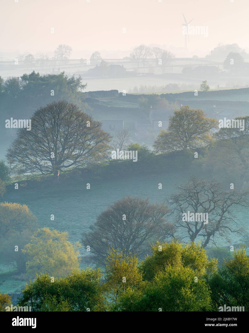 The rolling landscape surrounding Swinsty and Fewston Reservoirs is compressed into hazy layers on a misty spring morning. Stock Photo