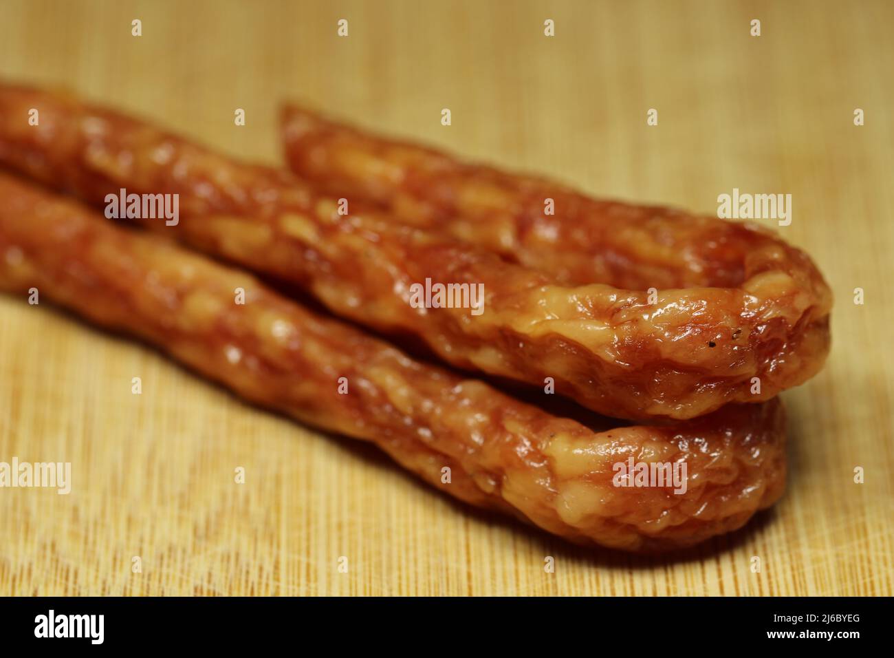 Thin sausage on a wooden board. Selective focus. Stock Photo