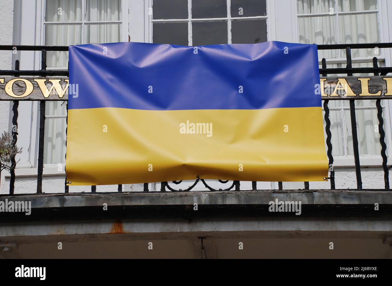 The national flag of Ukraine draped across the balcony of the Town Hall at Tenterden in Kent, England in April 2022. Stock Photo