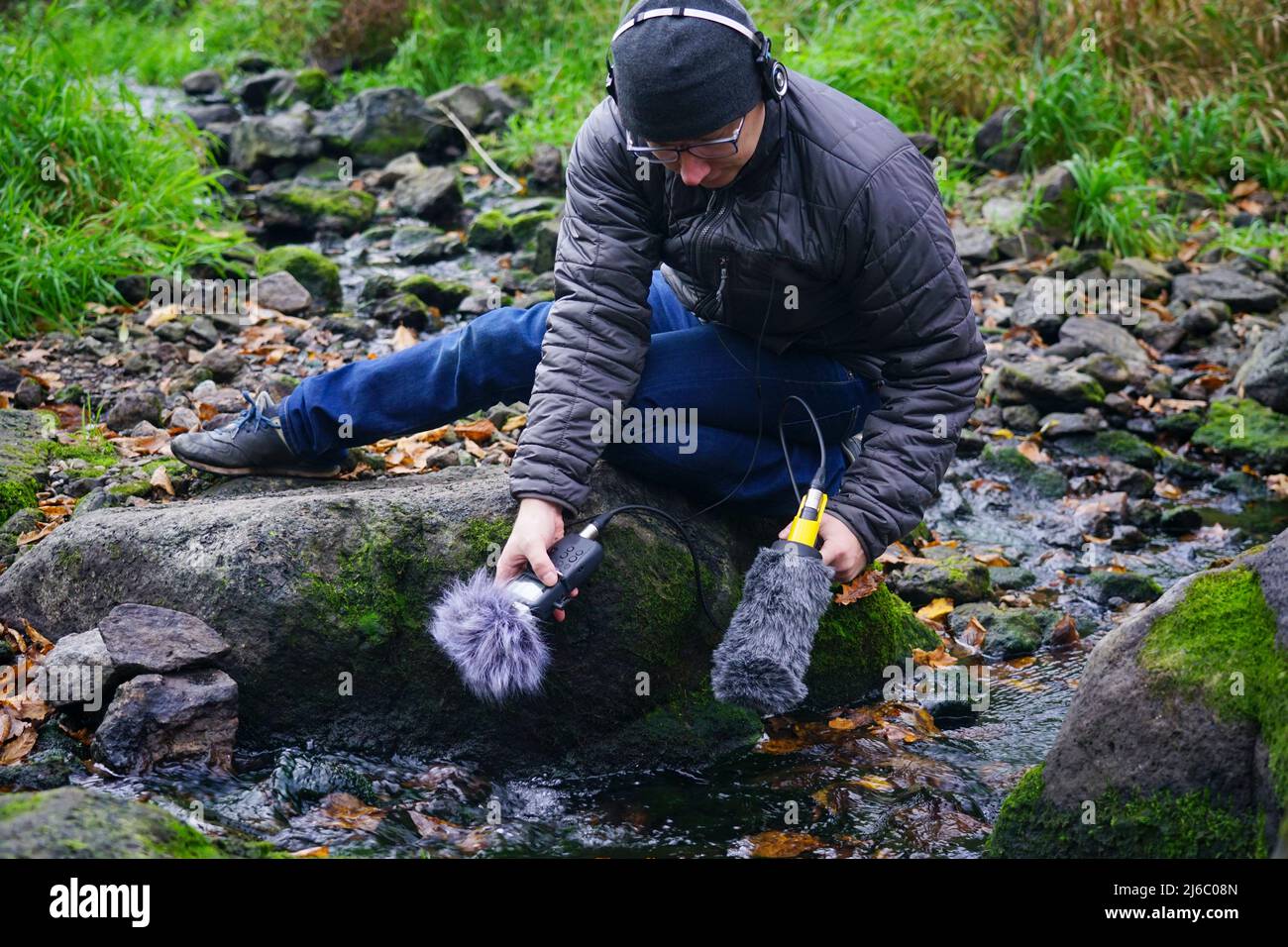 Hand holds a microphone gun to record sounds of nature. Sound