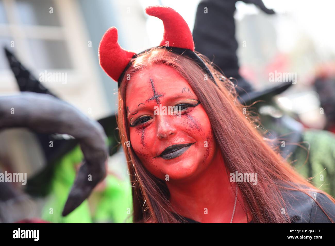 30 April 2022, Saxony-Anhalt, Wernigerode: A woman in a devil costume stands on the market square. On Walpurgis Day, people in witches' and devils' costumes have traditionally come together to storm the town hall in Wernigerode. In the whole resin, in addition, in other regions and er night to 1. May the traditional Walpurgisfest is celebrated. The strongholds include Thale and Schierke am Brocken. Photo: Matthias Bein/dpa Stock Photo