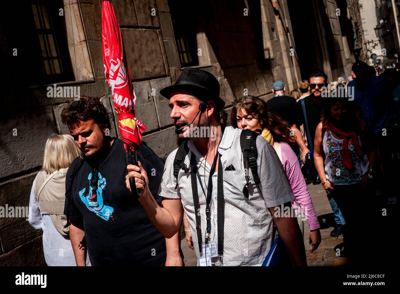 Barcelona, Spain. April 30, 2022. A tour guide makes his way followed by tourtists through the narrow streets of the Gothic quarter in Barcelona. After two years of pandemic and with the end of all restrictions, mass tourism is back to the Mediterranean city of Barcelona, opposition forces in the Barcelona City Council are asking for measures to alleviate the effect of tourist overcrowding on some neighborhoods of the city. Credit:  Jordi Boixareu/Alamy Live News Stock Photo