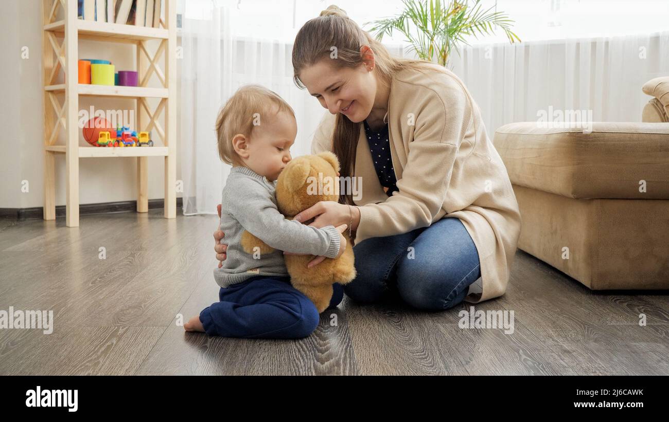 Mother and baby boy playing with teddy bear Stock Photo - Alamy