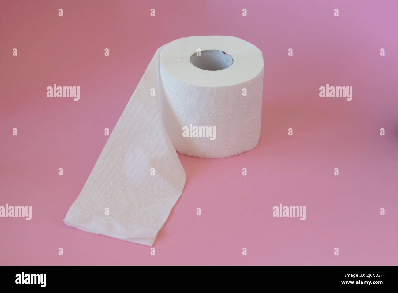 Rolls of white toilet paper on a pink background Stock Photo