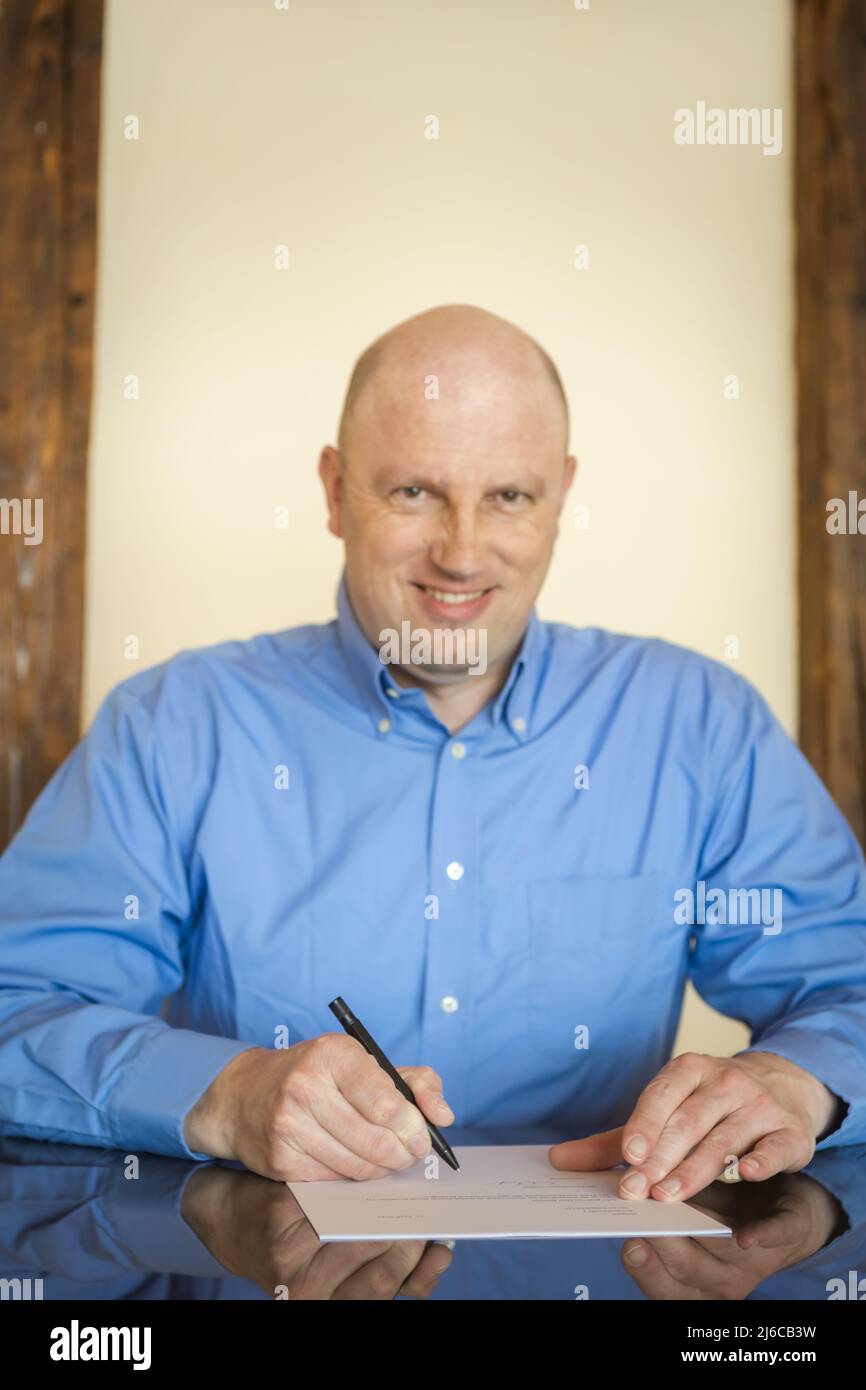 A businessman signs a contract on desk. Stock Photo