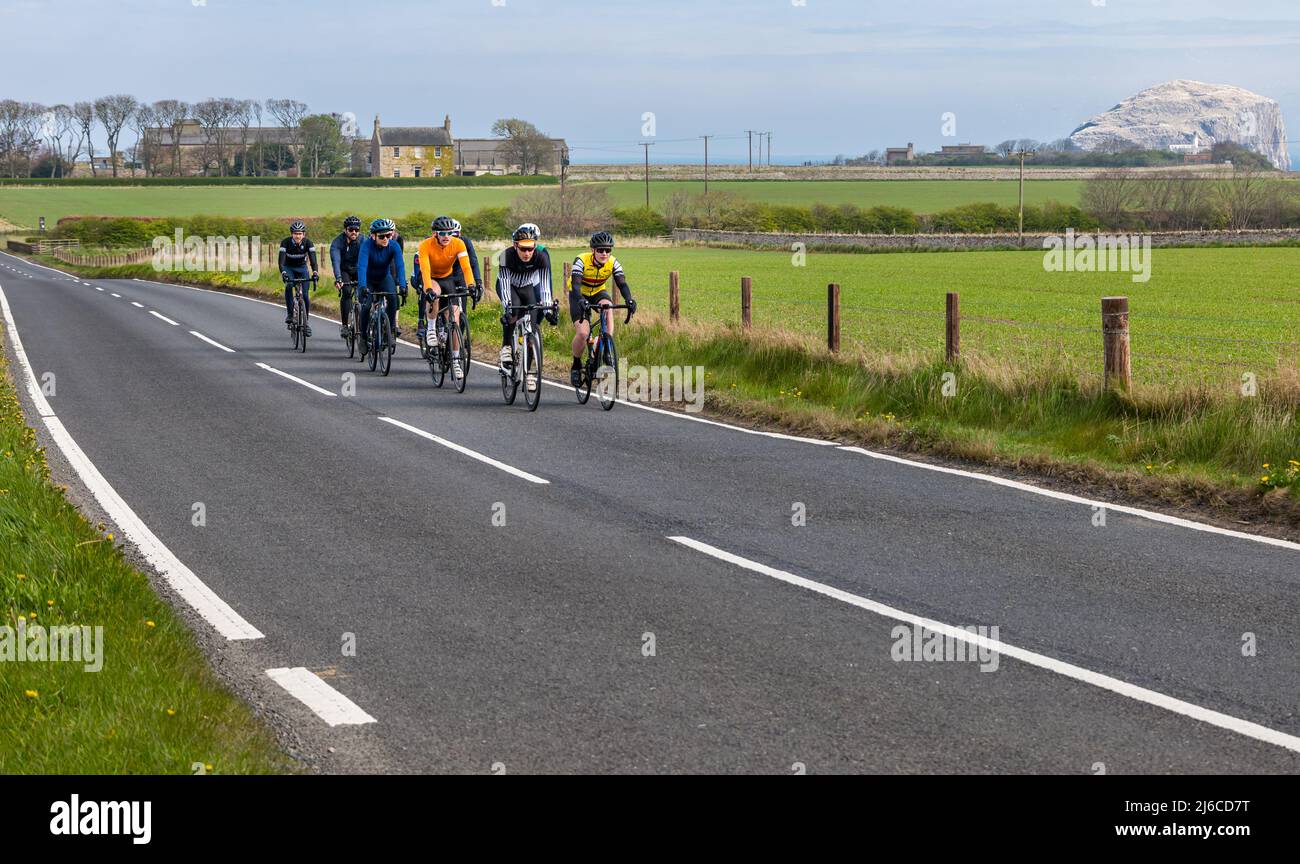 Group of cyclists cycling on quiet coastal country road near Bass Rock, East Lothian, Scotland, UK Stock Photo