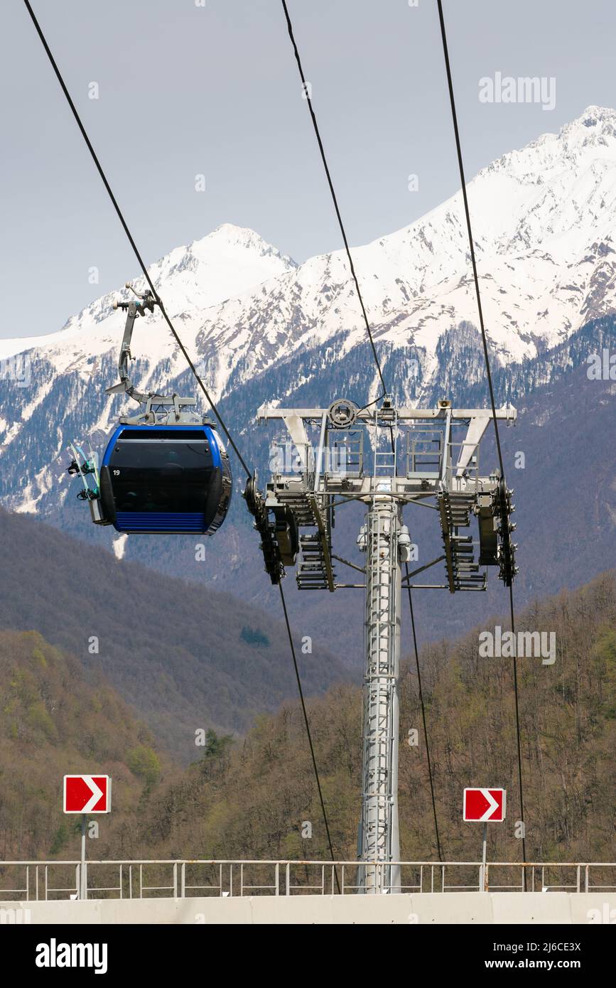 Scenic mountain landscape with cable car of Krasnaya Polyana resort. Cable lift cabins with a view of the Caucasus Mountains. Springtime. Stock Photo