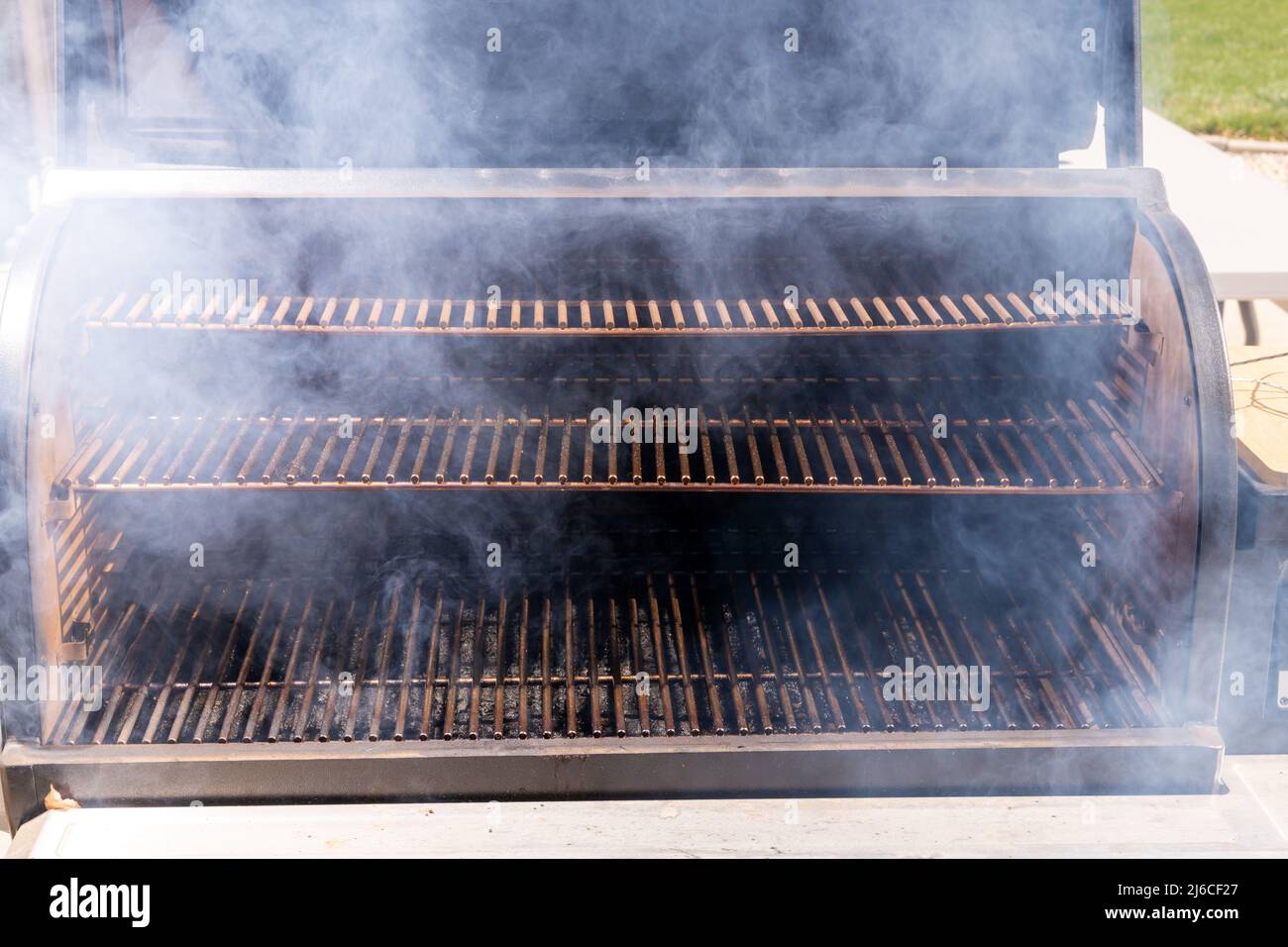 Levels of grates on a smoker filled with smoke Stock Photo Alamy