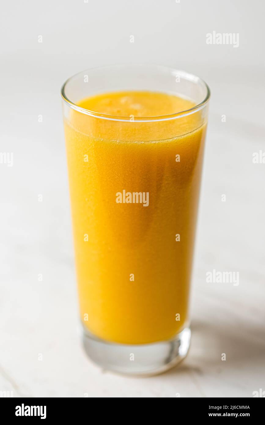 Healthy Detox Orange and Yellow Citrus Smoothie Glass Stock Photo
