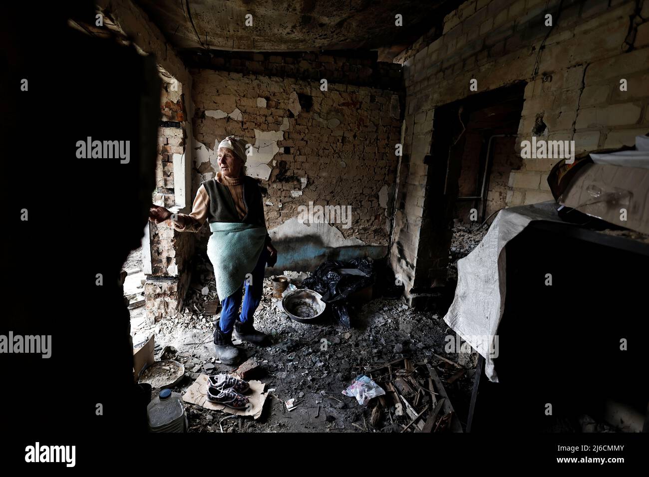 Hanna Selivon, 77, stands in what remains of her house, which according to her was destroyed by Russian shelling, amid their invasion of Ukraine, on the outskirts of Chernihiv, Ukraine April 30, 2022. Selivon said she now lives at the volunteer center in downtown Chernihiv and bikes everyday to her home to try to recover her belongings. REUTERS/Zohra Bensemra Stock Photo