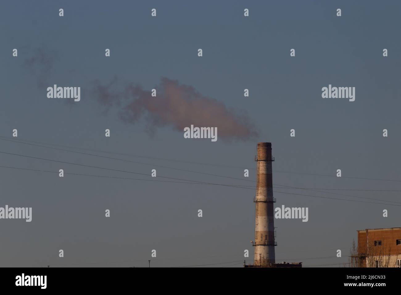 Pipes of an old factory throw clouds of poisonous white smoke into the sky polluting the