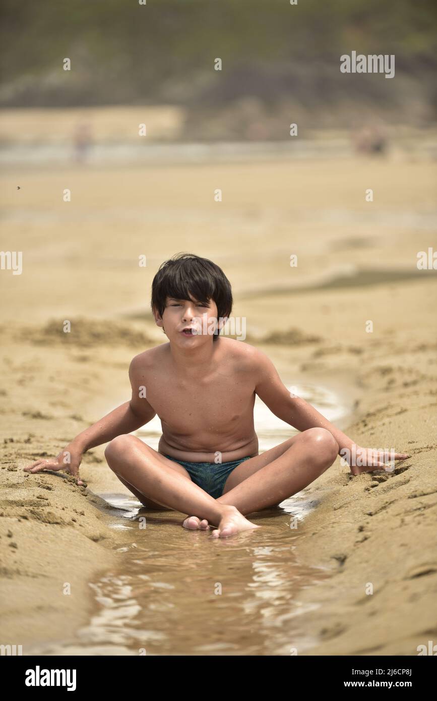 portrait of a child sit in the beach in summer wear Stock Photo