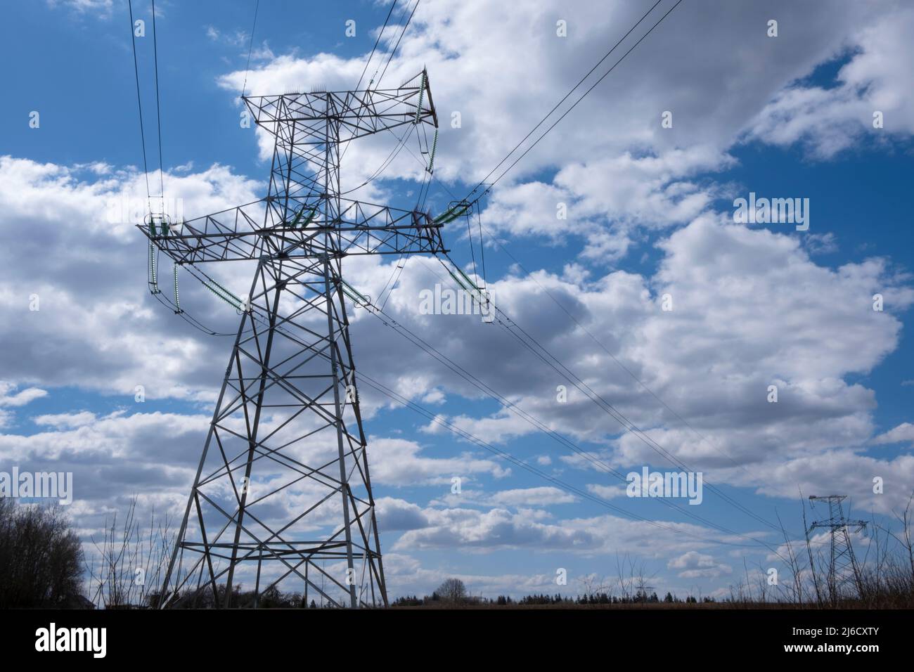 Tower of a high-voltage power line against the of blue sky and clouds ...