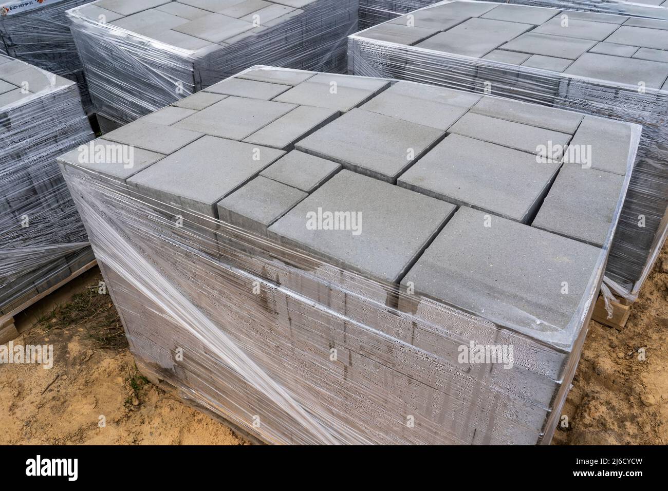 Laying of gray concrete paving slabs in the house courtyard driveway