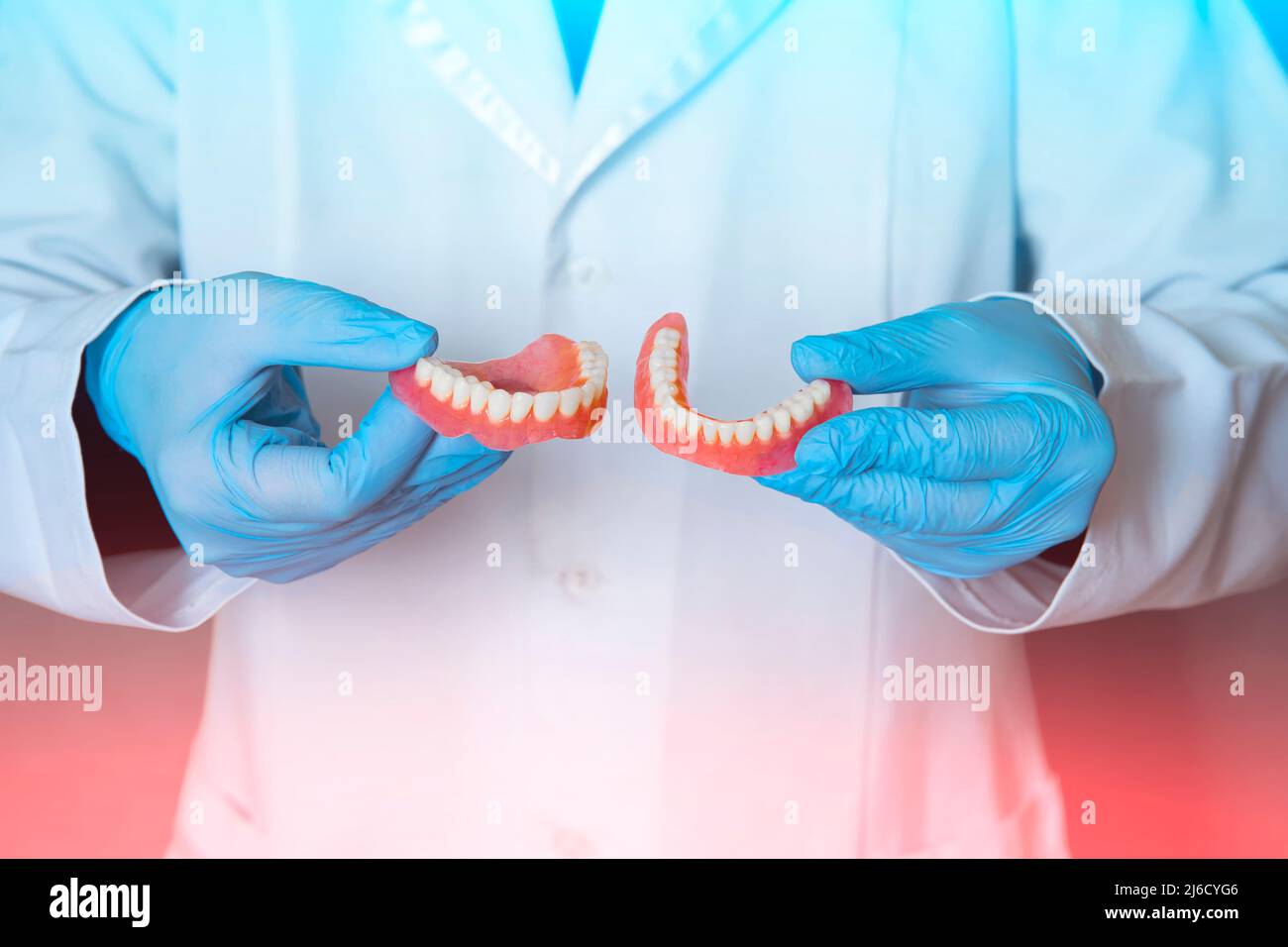 Dental prosthesis in the hands of the doctor closeup. Dentist holding