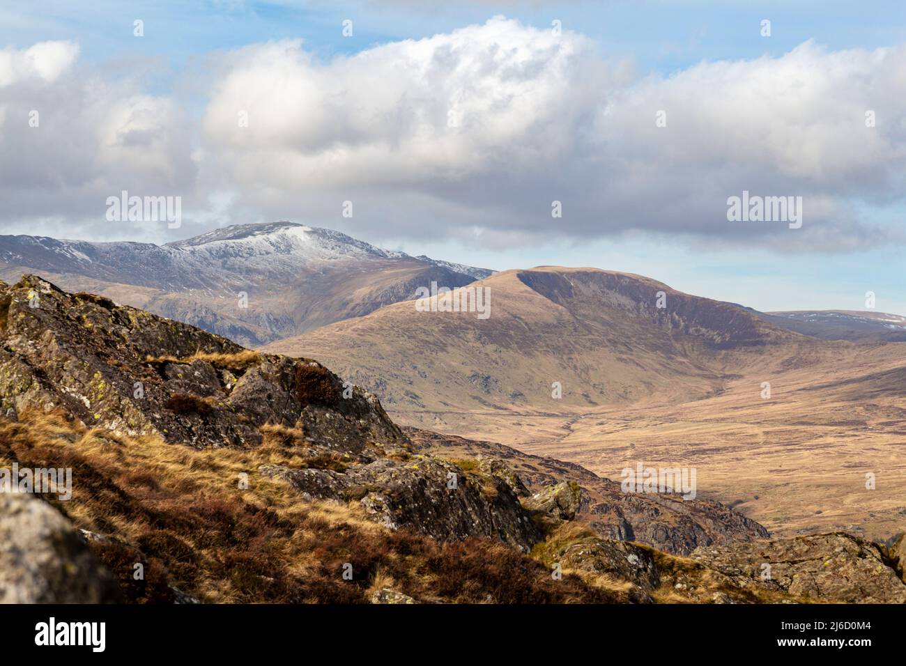 Looking towards the Carneddau mountain range, with a snow capped Carnedd Llewelyn and Pen Yr Helgu Du, from the side of Moel Siabod Stock Photo