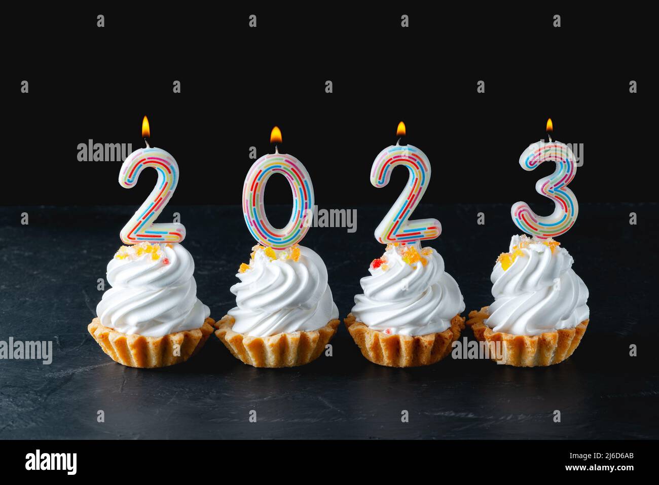 Festive cupcakes and candles in form of numbers 2023 on black background  Stock Photo - Alamy