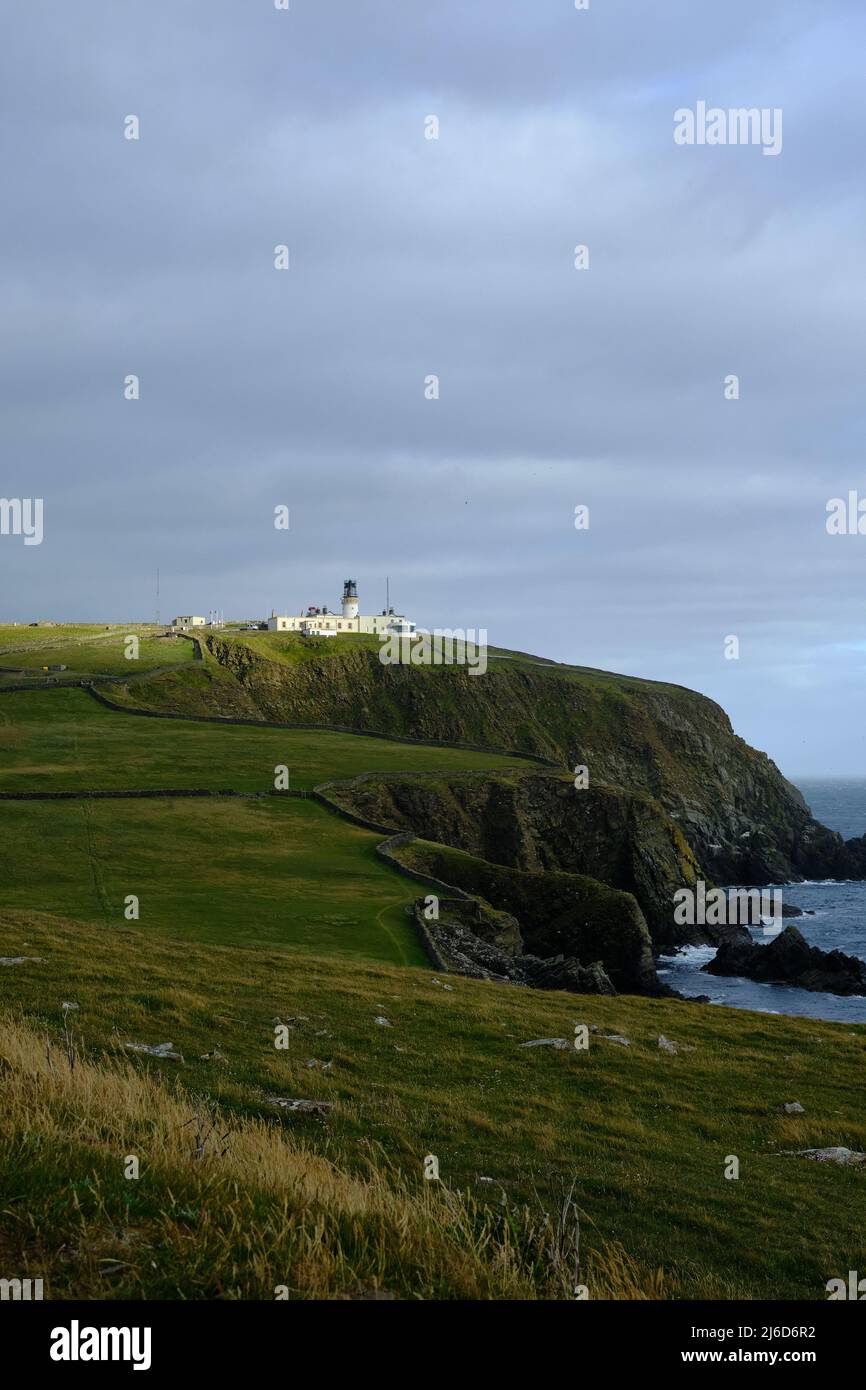 Sumburgh Head lighthouse in Shetland seen from a distance Stock Photo