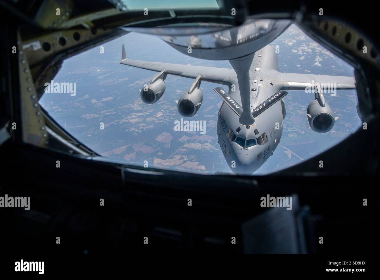 A U.S. Air Force C-17 Globemaster III, assigned to Joint Base Charleston, South Carolina, descends after receiving fuel from a KC-135 Stratotanker assigned to MacDill Air Force Base, Florida, over the Southeastern United States, April 21, 2022. The C-17 is capable of rapid strategic delivery of troops and various types of cargo to main operating bases or directly to forward bases in the deployment area. The C-17 is operated by Air Mobility Command from Travis AFB, California; Dover AFB, Delaware. Joint Base Lewis-McChord, Washington; Joint Base Charleston, and Joint Base McGuire-Dix-Lakehurst, Stock Photo