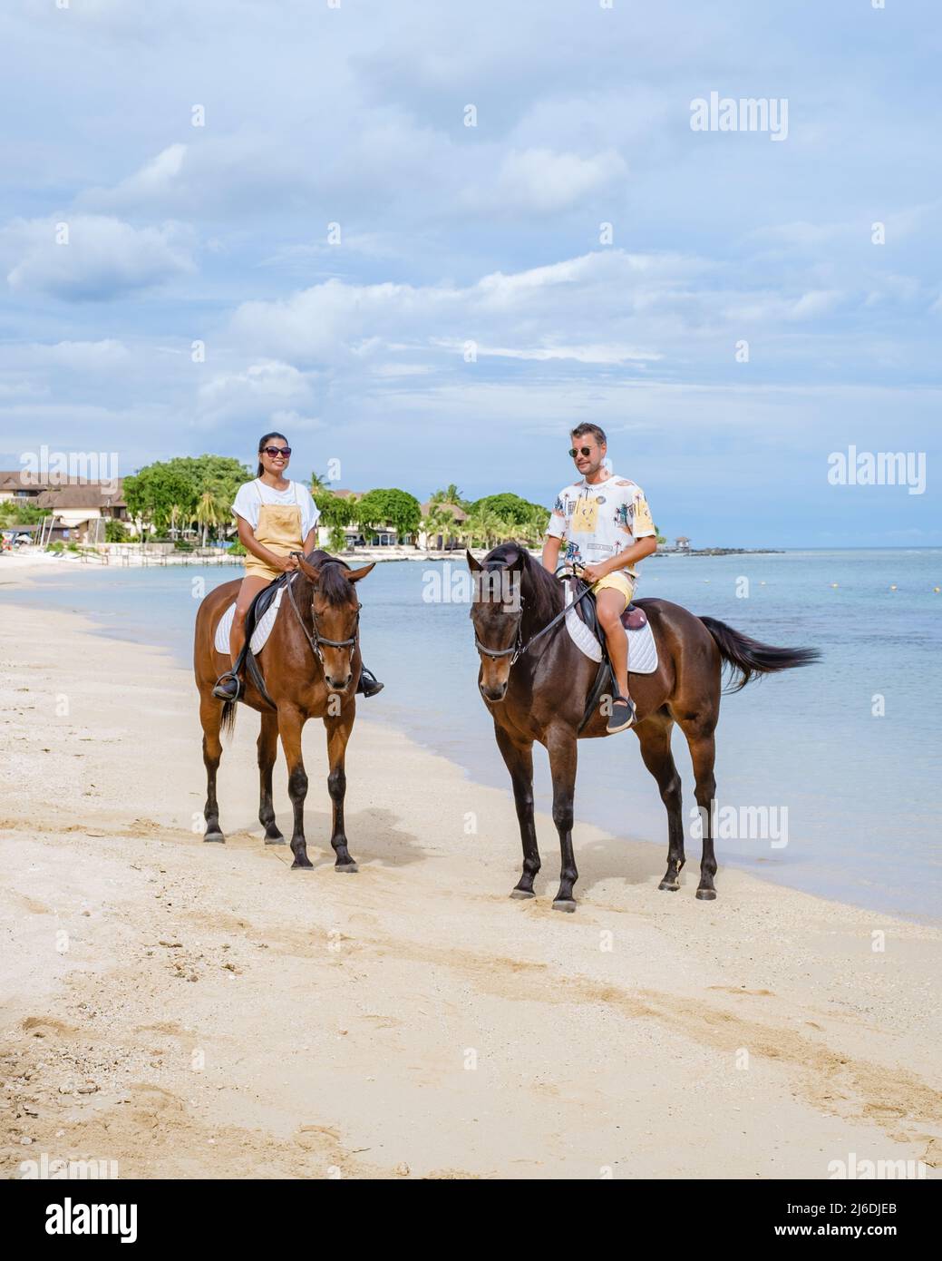 horse riding on the beach, man and woman on a horse on the beach during