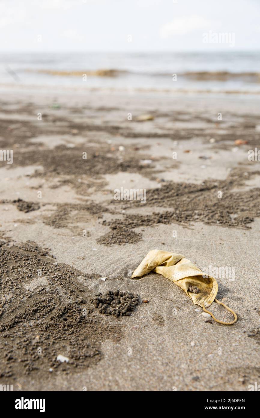 Masks are discarded on the beach, marine garbage. Stock Photo