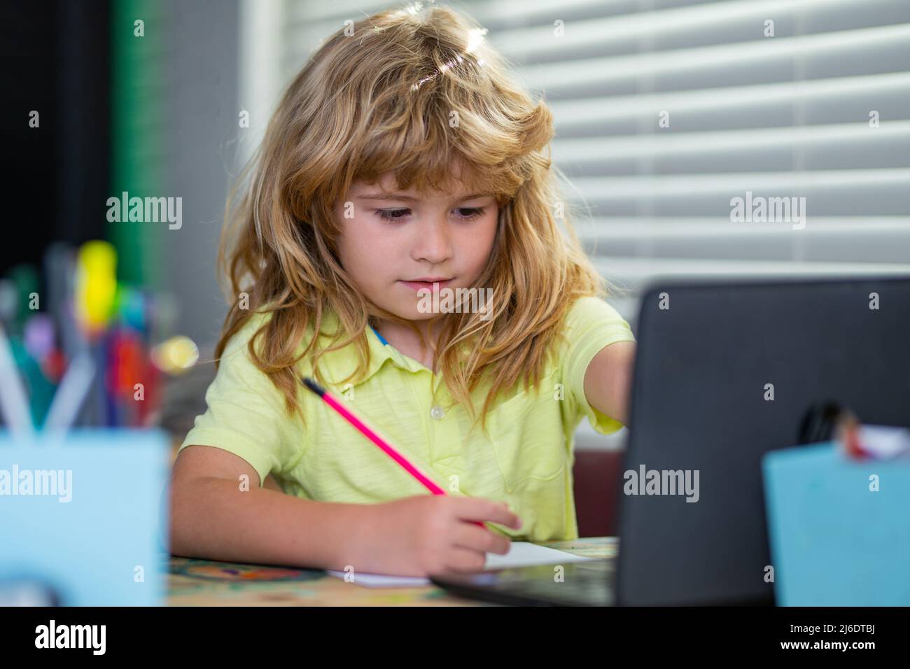 School boy doing homework writing and reading at home. Concentrated child writing in notebook