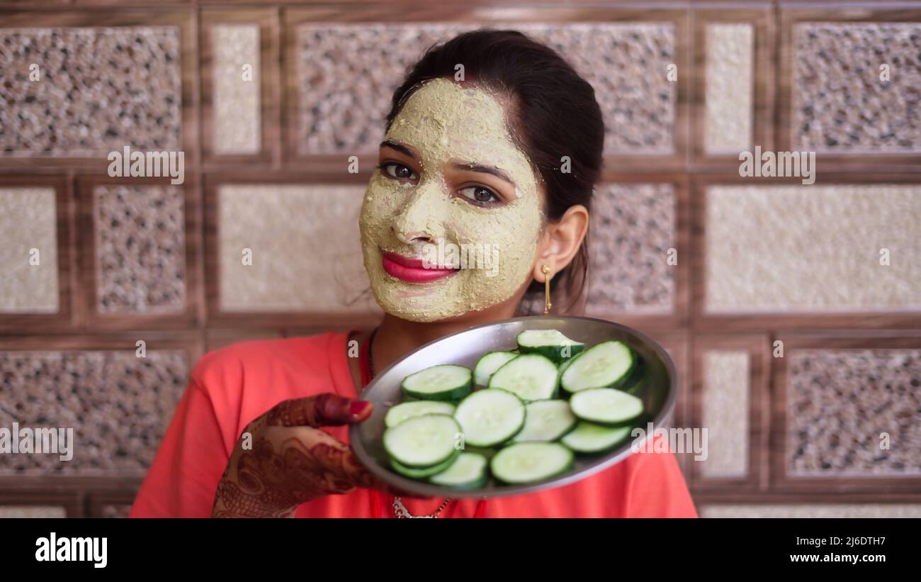 A Woman With Facial Mask And Fresh Cucumber On Eyes Relaxing At Home