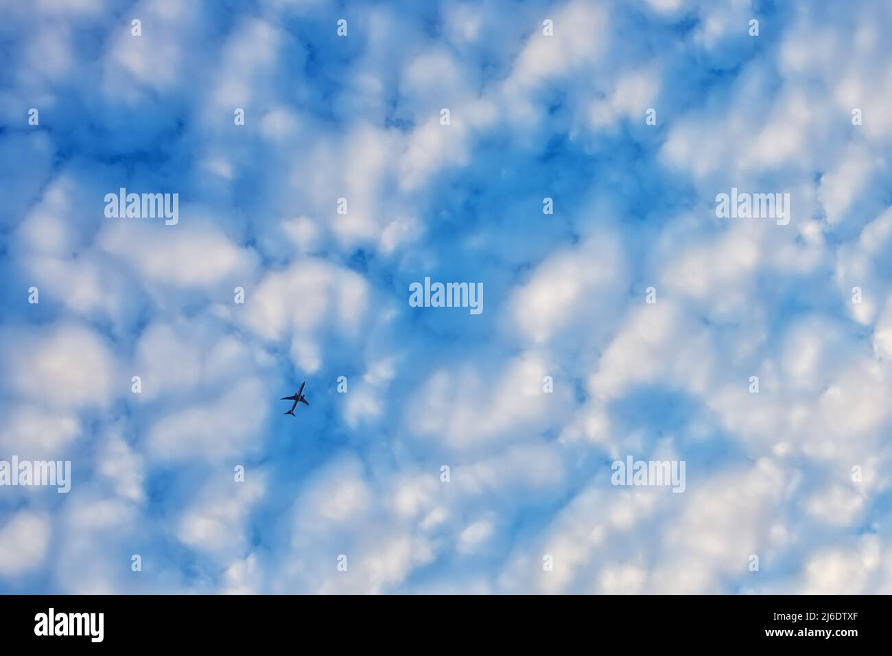 plane flying on blue sky with fluffy clouds Stock Photo - Alamy